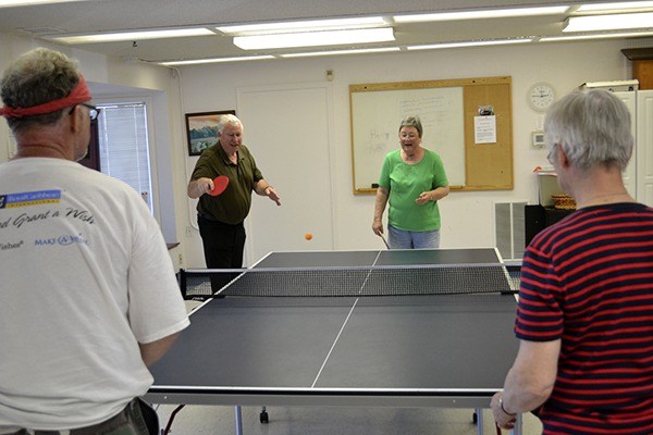 Stuart Mackenzie serves the ball in a ping pong match at the Shipley Center with teammate Helga duBellier against Joseph Wright and Agneta Johnson last week. Ping pong runs four days a week with a beginners class at 10 a.m. most Mondays.