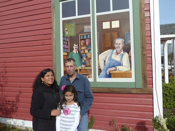 Matt Dryke shows wife Yvonne and daughter Ellen Lehman a mural recently put up on the old Sequim Town Hall.