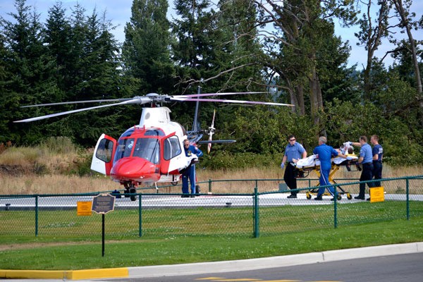 Paramedics with Clallam County Fire District 3 and Olympic Ambulance help a motorcyclist onto a helicopter prior to transport to Harborview Medical Center for injuries in a Monday afternoon wreck.