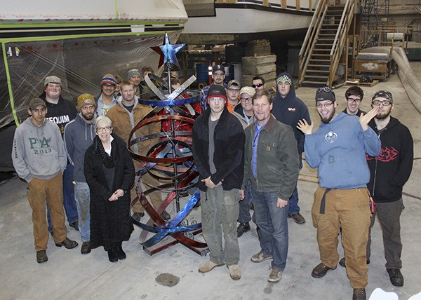 Peninsula College welding department students — pictured here on tour of the Platypus Marine facilities — take a few moments to show off a tree created by two of their classmates.