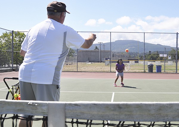 Nine-year-old Crystal Rieckhoff of Port Angeles volleys as tennis pro Don Thomas of  Sequim gives instruction at the Sequim High School tennis courts last week. Rieckhoff says she plans on entering the Juniors Tennis Tournament
