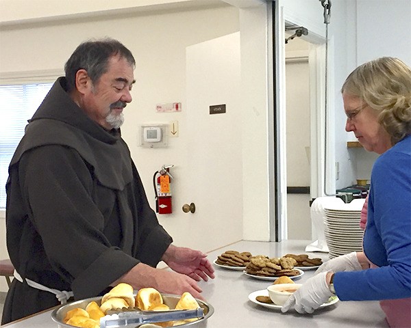 'Chef' Dianne Onnen passes a lunch tray to Fr. Bill Tartar for delivery.
