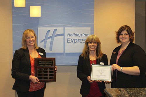 Holiday Inn Express in Sequim accepts the Clallam County Health & Human Services Business Leadership Advisory Committee Employer of the Month Award from Carrie Heaton