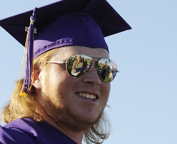 Sequim High School senior Wyatt Billings is all smiles as he prepares to receive his diploma and congrats  from Sequim School Board president Bev Horan and SHS principal Shawn Langston on June 12.