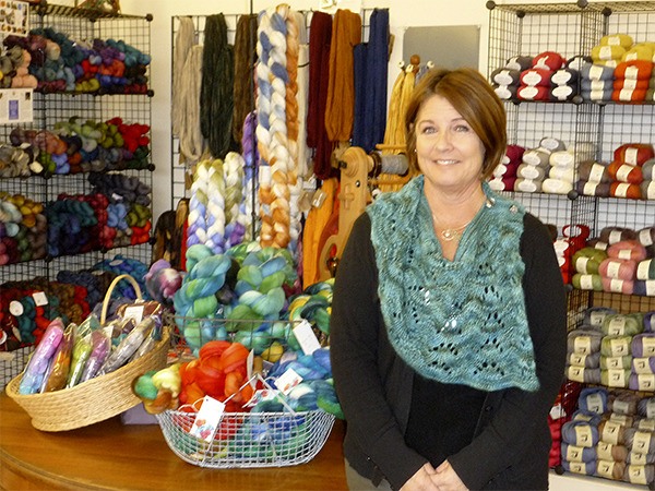 Terry Mendicino is flanked by the wide variety of yarn she carries in her new store