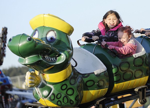 Enjoying the “Go Gator” roller coaster ride at the carnival on Fir Street fields Saturday are Malena Marquez