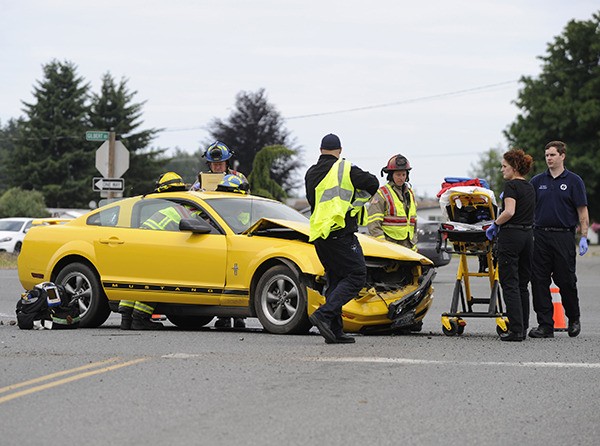 Emergency personnel aid an injured driver on the scene of a two-vehicle wreck on U.S. Highway 101 Thursday morning.