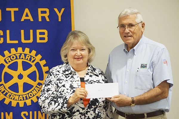 Sequim Sunrise Rotary Club president Carolyn McGinty makes a check presentation to Jim Pickett.