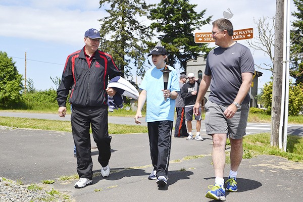 The torch makes its way through Sequim last week for the Washington Special Olympics 2014 Summer Games May 30-June 1. Brett and Blake Yacklin