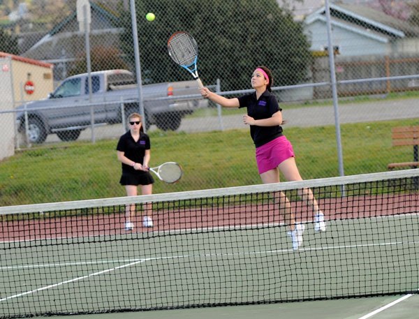 Cheyenne Sokkappa returns a hit next to doubles teammate Katelyn Wake on the recently repaired lower courts at Sequim High School. They were closed for about six months due to cracks and an uneven playing surface.