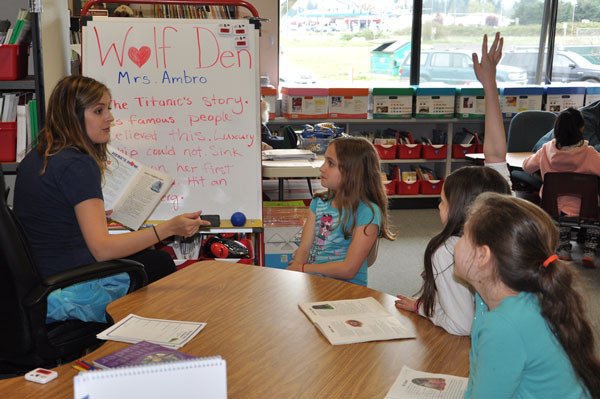 Washington Reading Corps member Holly Ambro (far left) works with Jayden Ristick