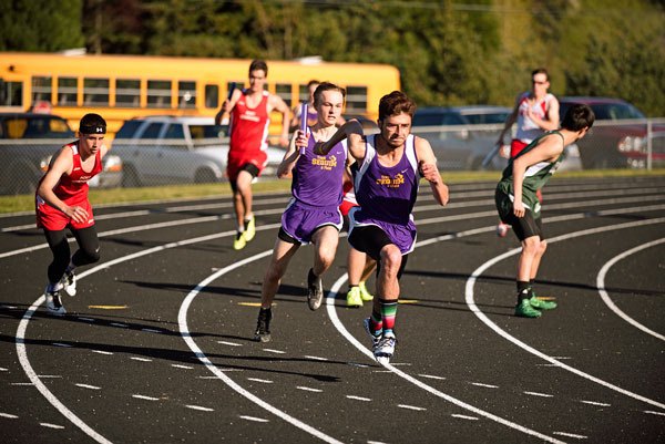 Sequim’s Quintan Johnson looks to hand off to anchor Oscar Herrera in the 4x100 relay event last week in Port Townsend. Sequim won the event with a 45.88-second mark.