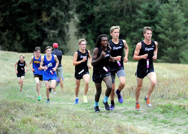 Sequim’s varsity boys squad charges up the meadow hill at Robin Hill County Park last week. Sequim’s boys took seven of the top nine places in an Olympic League meet sweep of North Mason and Bremerton on Sept. 16. Pictured above in the lead pack are