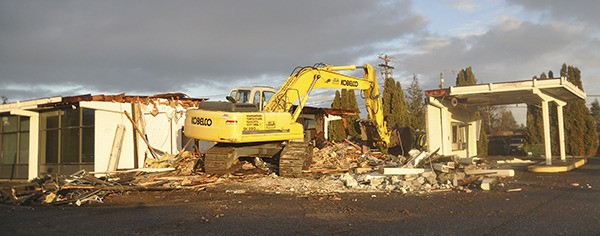 Crews with C&J Excavating of Carlsborg begin knocking down the former Sequim Clallam PUD customer service building at 410 E. Washington St.