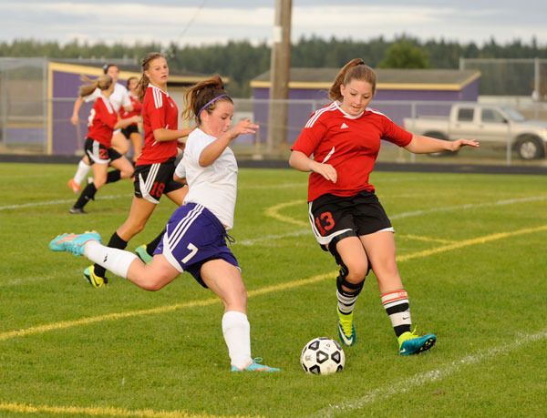 Sequim forward Aylee Bennett (7) looks to put a shot on goal past Coupeville’s Jennifer Spark early in the second half of the Wolves’ 1-1 draw with Coupeville on Sept. 17.