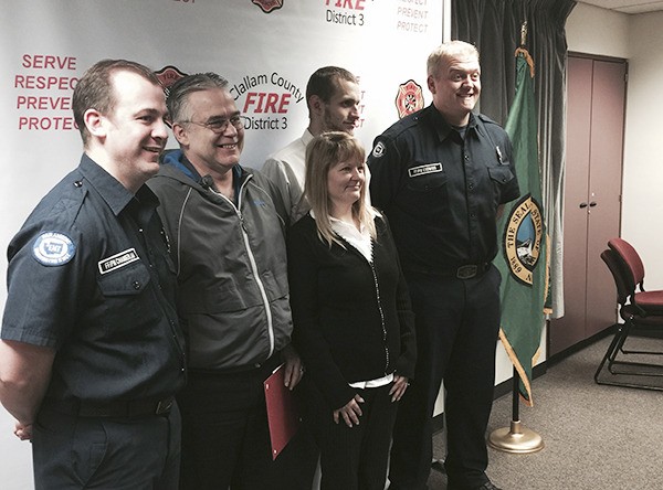 Representatives from Clallam County Fire District 3 celebrate a pair of Walmart employees last week for helping save the life of a customer.