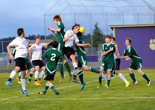 Sequim’s Liam Harris goes up for a header among a crowd of Roughriders late in the game on April 21.