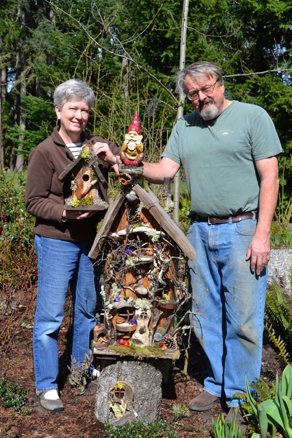 Val and Nancy Jackson stand outside their home next to one of their trademark Whimsical Woods gnome houses in 2012.