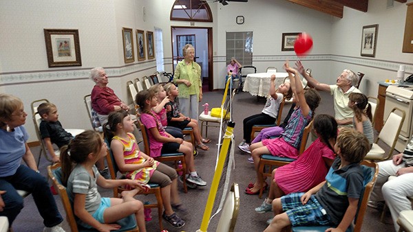 KinderKids play balloon volleyball with hosts from The Fifth Avenue Retirement Center.