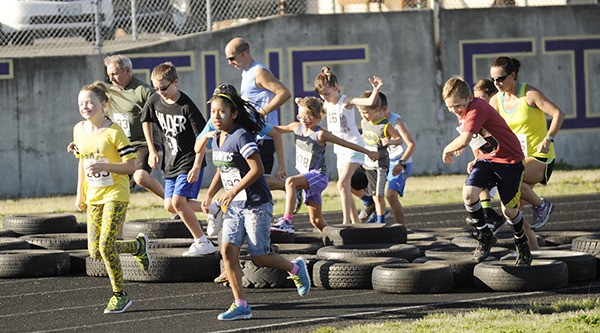 More than five dozen runners and walkers take on the first obstacle at the 2015 Back 2 School Family Fun Run. The event is a fundraiser for the Sequim Education Foundation