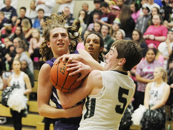 Port Angeles’ Noah McGoff ties up Sequim forward Nick Faunce as Faunce looks to score a basket in the teams’ Jan. 8 matchup. Sequim jumped out to a 10-0 lead but Port Angeles prevailed