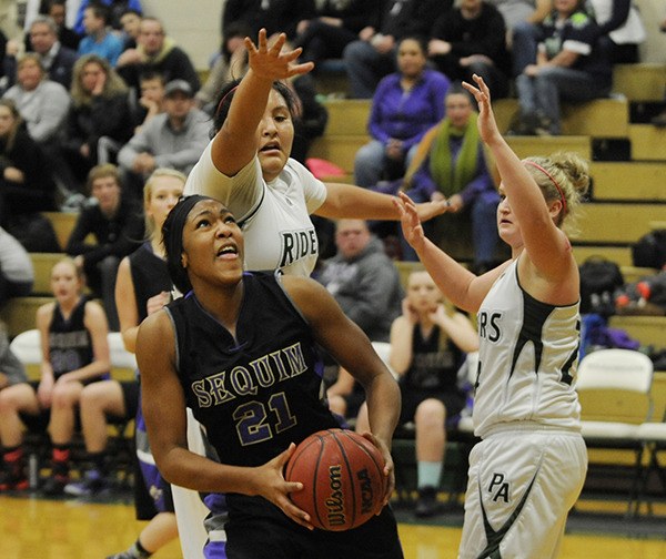 Sequim’s Adrienne Haggerty muscles inside the Port Angeles defense for a shot attempt. The Riders’ Nizhoni Wheeler (center)