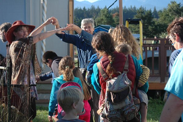 Five Acre School founders Juanita Ramsey-Jevne and Bill Jevne create an arch to allow for all the 2014 students enrolled in Five Acre School to pass through during the school’s first day opening ceremony. The 2014 school year marks 20 years in operation for the independent school neighboring the Dungeness National Wildlife Refuge. As in the past 19 years