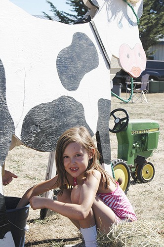 Katelynn Sharpe of Sequim practiced milking the Museum & Arts Center’s demonstration cow during MAC’s Fun Day
