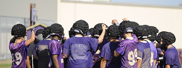 Sequim High School’s varsity football players rally together after finishing a preseason practice drill. The Wolves open the season Friday