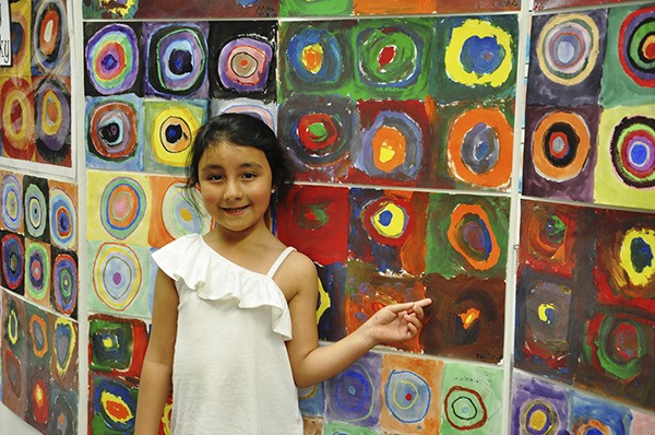 Kindergartner Paloma Franco from Stephanie Grotzke-Nash’s class points out her work at the Aspiring Artists & Promising Painters Art Show.