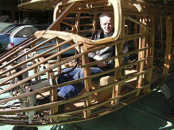 Frank Wajda tries out the cockpit of his bush plane-in-process. He has been steam-bending Sitka spruce for years to create the framework. The plane’s wingspan is 36 feet.