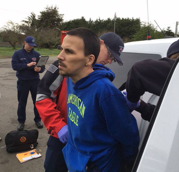 Medics with Clallam County Fire District 3 treat alleged burglar Robert D. Akin on March 9 after he was struck by a pistol after being found inside a Dungeness home.