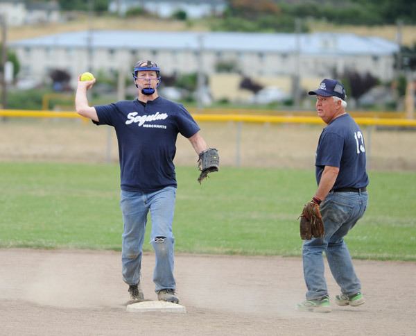 Shortstop Dave Pugsley turns a double play at second base as teammate Mike Schmoll looks on.