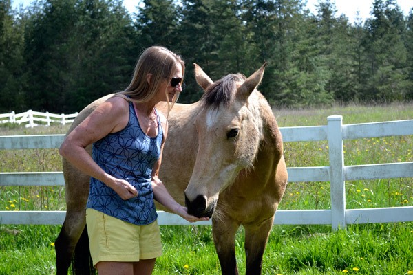 Sequim author Lisa Preston treats her 14-year-old horse Juneau outside her home. Aside from her love for riding and running