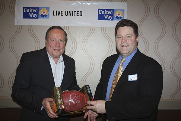 United Way of Clallam County board president Don Bradley (left) presents an autographed football to 2013 Campaign chairman Buck Gieseke.