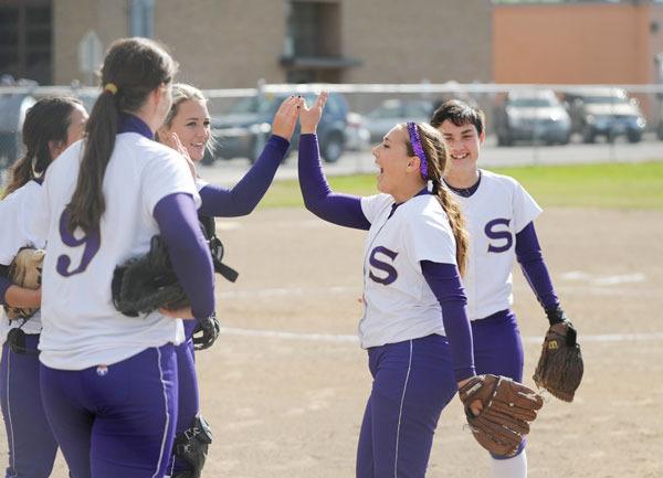 Sequim’s McKenzie Bentz (left) and Halie Wilson (far right) congratulate teammate  Tia Bourm. after the right fielder made a racing catch to save a run in Sequim’s 6-4 win against   Kingston last week.