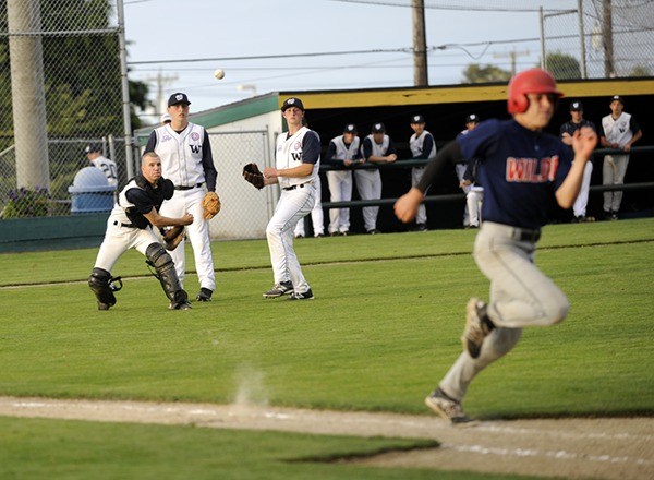Wilder Senior catcher Brett Wright throws out a runner after a bunt while third baseman Ryan Mudd and pitcher Nick Johnston look on.
