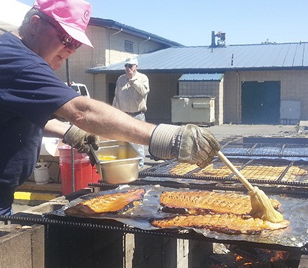 Rotarian Jim McEntire helps cook up fine dishes of fish at the Rotary Club of Sequim’s 46th annual salmon bake and barbecue at the Sequim Boys & Girls Club on Aug. 10. Proceeds benefit Sequim children