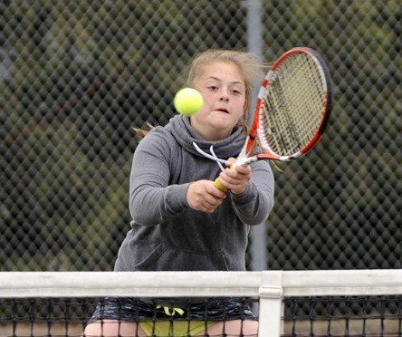 Hannah D’Amico returns a serve against a Port Angeles opponent on April 28 playing with doubles partner Isabella Hugoniot.