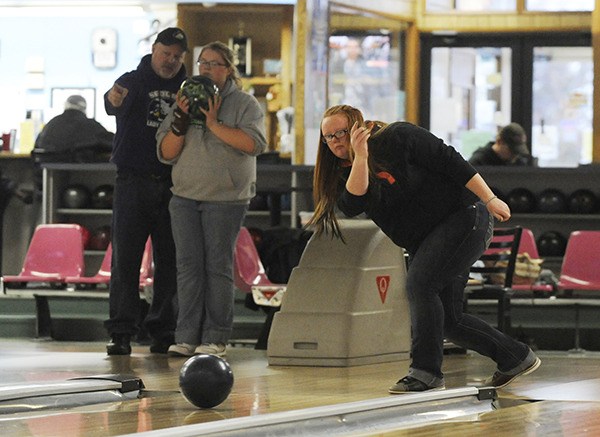 As Sequim High School bowling coach Randy Perry talks with sophomore Dakota Henderson (at left)