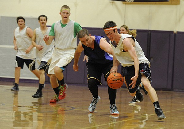 Sequim High senior Anthony Pinza strips teacher Greg Glasser of the ball and drives in for a basket as the senior class takes on school staffers on April 16. Thanks to some timely class donations that (by rule) added to their overall score