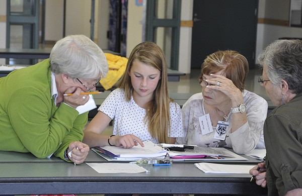 Sometimes four heads are better than one: Sixth-grader Ava Rich works with volunteer math tutors (from left) Sherry Niermann