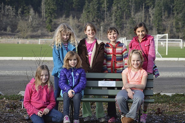 Current and former Brownies with Girl Scout Troop 43630 in Sequim pose with a bench they donated to the City of Sequim with funds from last year's Girl Scout cookie sales.