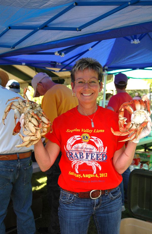 Jodi Simmons of the Sequim Valley Lions Club holds up three of 400 dungeness crab supplied for the 2014 crab feed on June 28.