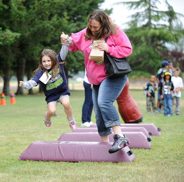 Erin Kanicky helps Wynter Miller clear the hurdles in a game at the Dungeness Bay Sea Hawkers event on Saturday.