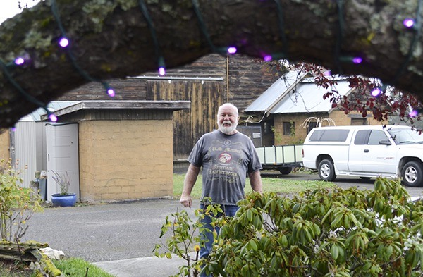 Tom Ledford stands outside his home with purple lights glowing to commemorate his wife Judee's battle with pancreatic cancer. He lights the tree on the 22nd of each month in her honor.