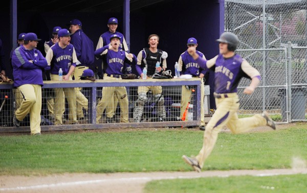 Teammates cheer on Sequim’s Gavin Velarde after a pair of steals and a wild throw led to a run in the Wolves’ non-league game against Vashon on April 15.