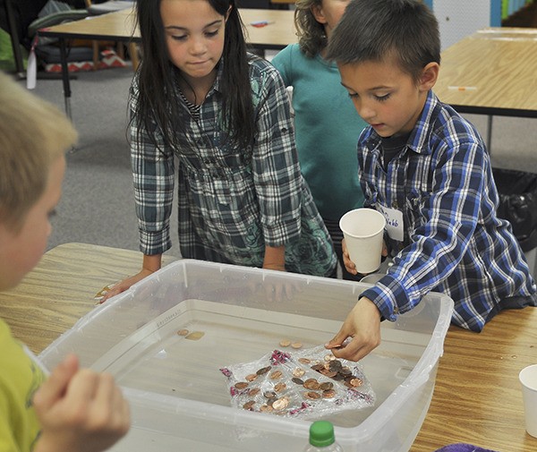 Areya and Tristen Winston-Webb see how many pennies Tristen’s boat can hold. Made of just Saran wrap