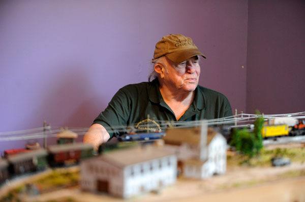 Steve Stripp sits with a portion of his planned model railroad in a room in his Sequim home. He says model railroading is a “peaceful time” and “a chance to go back.”