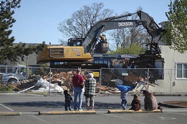 Onlookers watch as the Serenity House apartment building gets demolished.